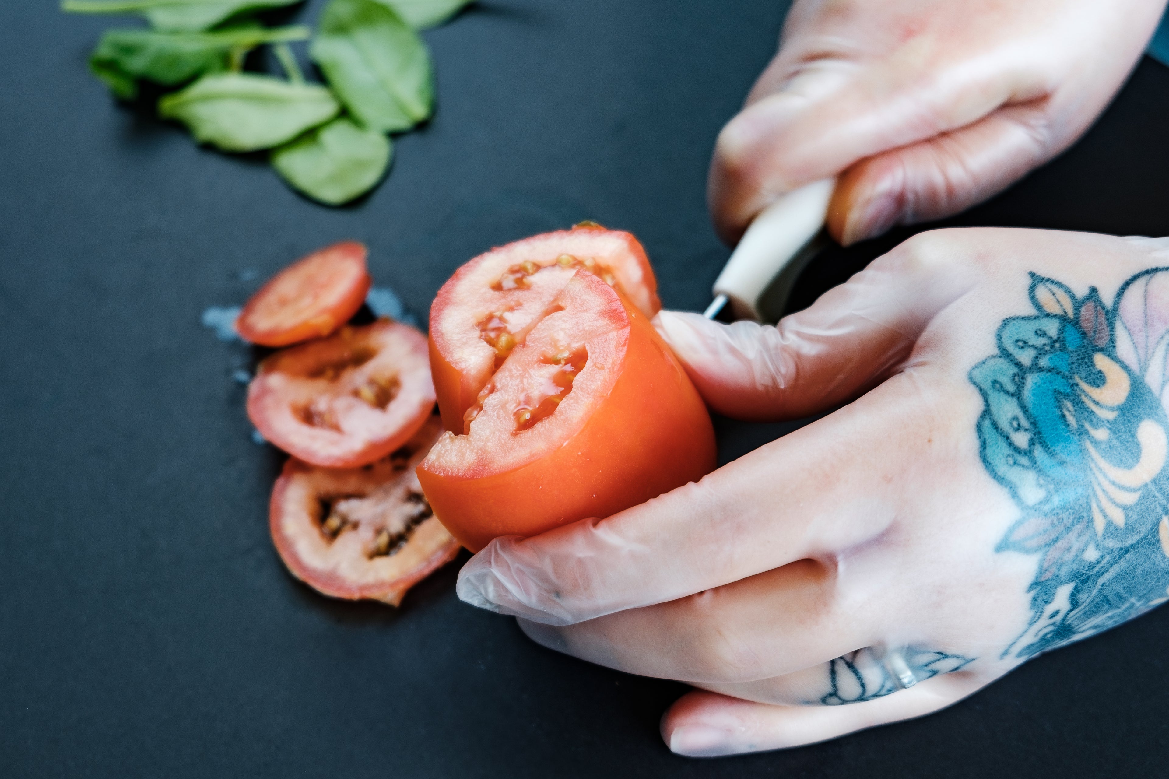 une personne coupe une tomate