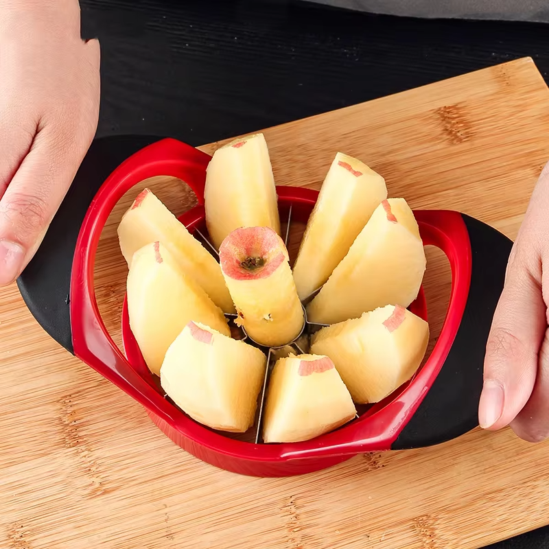 trancheur de pomme rouge en acier inoxydable coupant une pomme sur une table